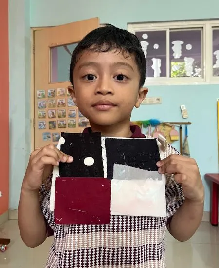 Siswa Playgroup memegang kain batik hasil karyanya